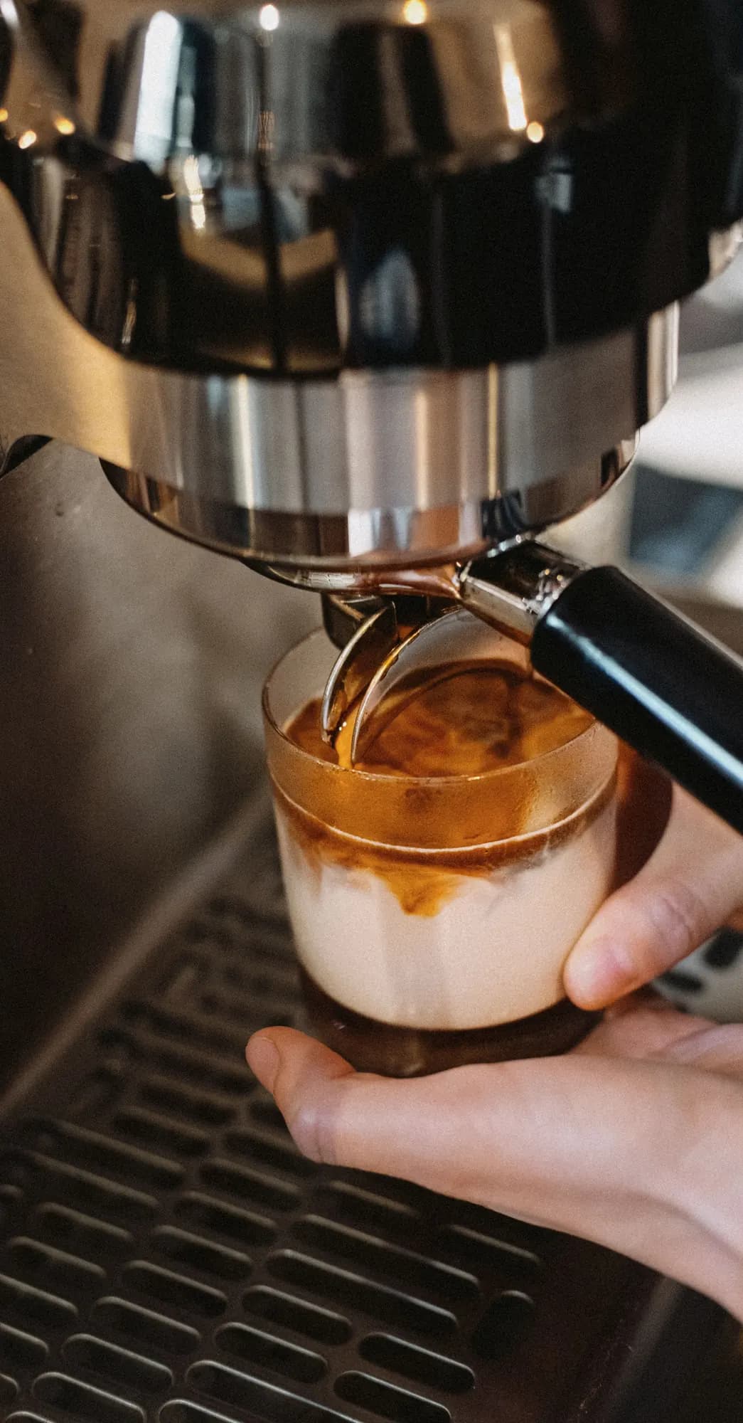 Espresso falling through milk in a clear glass