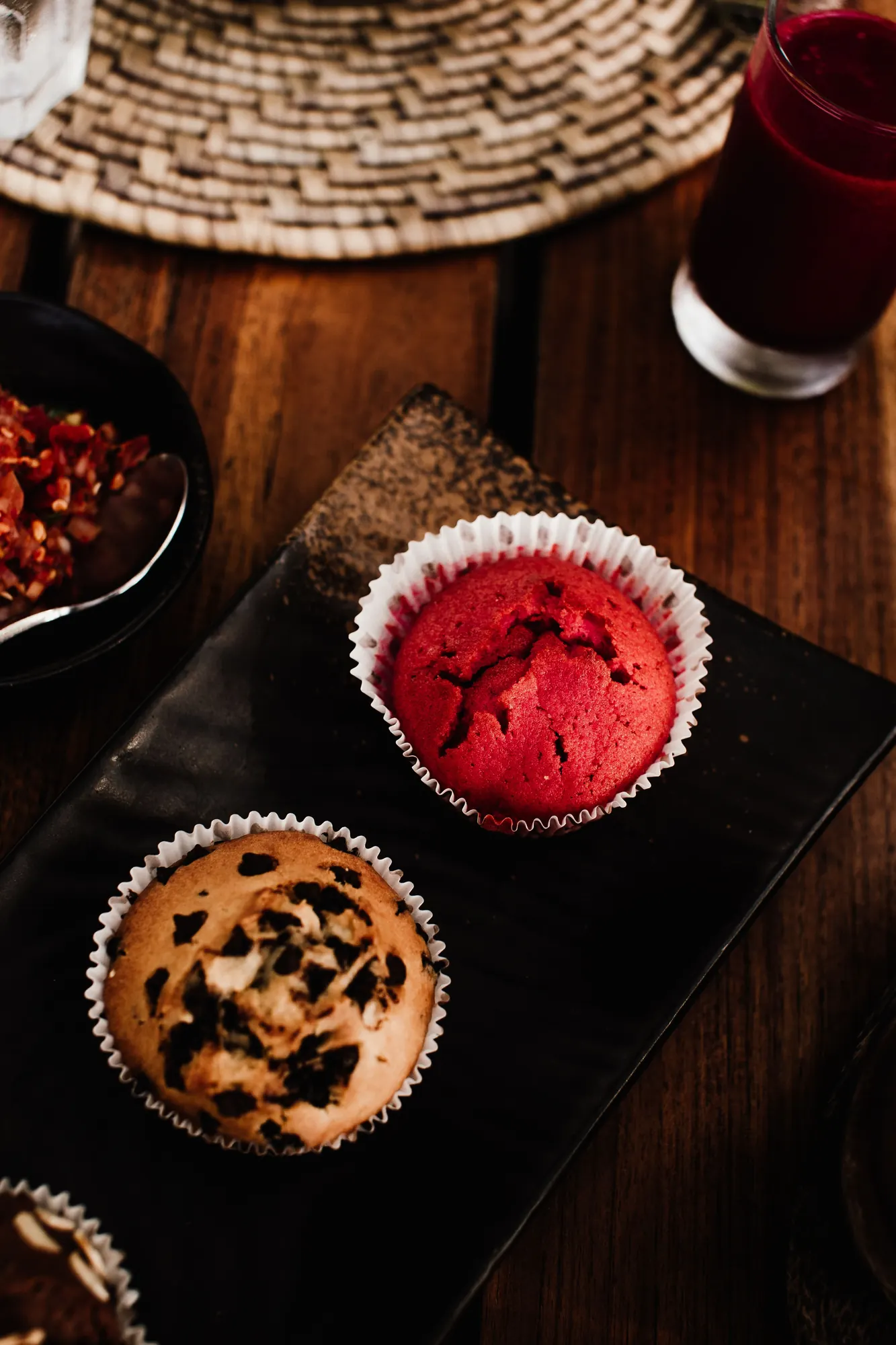 Red velvet and chocolate chip muffins on a dark slate board