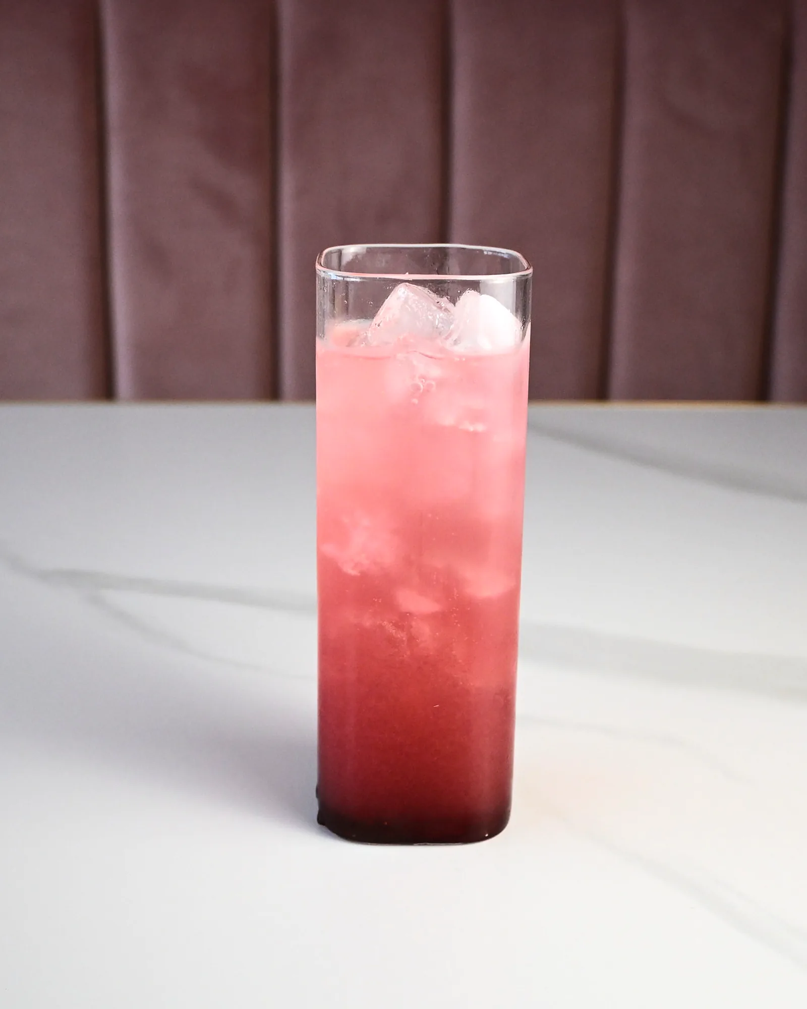 A tall pink refresher over crushed ice