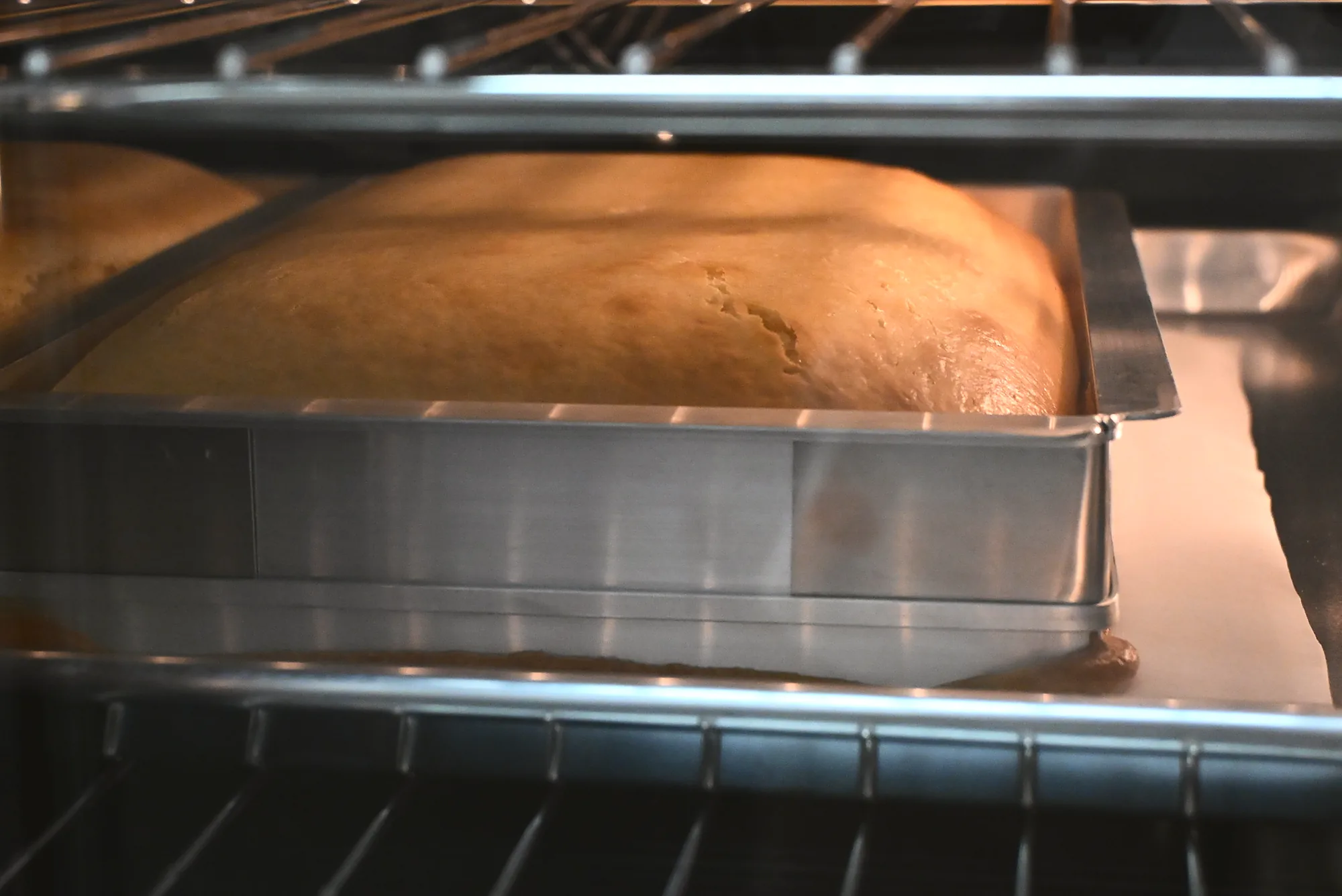 A sponge baking in its tin on the oven rack at the café